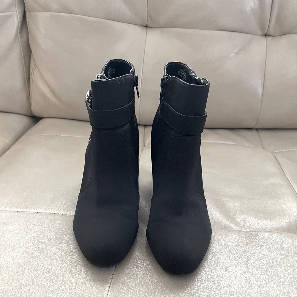Ankle bootie from Unisa with C-shaped buckles and exposed zipper in silver.
